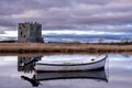 Boat Moored On The River Dee With Threave Castle In The Background, Scotland