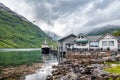 Boat moored to a pier in a small village in fjord. Norwegian landscape
