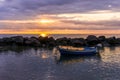 boat in morning or evening sea with rock pier and amazing sunrise or sunset with nice clouds on background of landscape Royalty Free Stock Photo