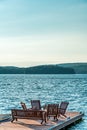 Wooden chairs on a dock which is lake side. Royalty Free Stock Photo