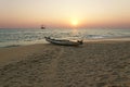 Boat on the ocean shore at sunset. Kerala, India