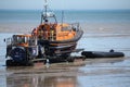 a boat parked on the beach with some people on it