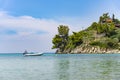 Boat parked on the sea, mountains and green trees on background during sunny day under blue sky with clouds in Greece Royalty Free Stock Photo