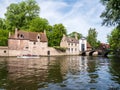 Boat with people, bridge over canal and entrance gate to Begijnhof, Beguinage, in Bruges, Belgium Royalty Free Stock Photo