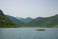 Boat with people floats on a large lake. Panoramic view on the lakeshore and powerboat.