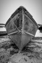 A boat pulled up on a lake shore beach from a dramatic angle in high contrast black and white Royalty Free Stock Photo