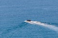 Boat racing across open ocean water. Boat speeding in the sea. Minimal nature photography. Beach view of maritime transportation. Royalty Free Stock Photo