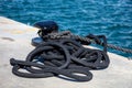 Boat ropes on black mooring bollard, luxury yachts marina pier Royalty Free Stock Photo