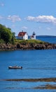 Boat running by Cutler Island Lighthouse. Maine coast