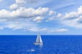 Sailboat sailing on the beach in Mallorca under a blue sky with white clouds Royalty Free Stock Photo