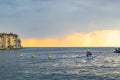 Boat sailing in the Adriatic Sea during sunset of a cloudy day with the typical croatian houses of Rovinj, Croatia, on the left Royalty Free Stock Photo