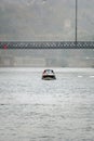 Boat sailing below the lower platform of the Don Luis steel bridge, with people walking with umbrellas due to the light rain and Royalty Free Stock Photo