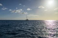 A boat sailing on the rippling blue waters of the Pacific Ocean off the coast of Oahu at sunset at Ko Olina in Kapolei Hawaii