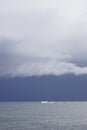 Boat sailing in the upcomming storm. Sailboat in bad weather sail at opened sea. Sailing yacht under heavy cloud sky. Royalty Free Stock Photo