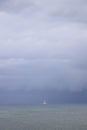 Boat sailing in the upcomming storm. Sailboat in bad weather sail at opened sea. Sailing yacht under heavy cloud sky. Royalty Free Stock Photo