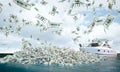 boat in the sea with island of dollars, money falling from the sky Royalty Free Stock Photo