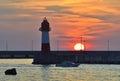 Boat at the sea lighthouse at sunset Royalty Free Stock Photo