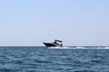 A small boat sails on the sea at speed on a hot, sunny summer day. Royalty Free Stock Photo