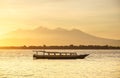 Boat on seashore during the sunrise. Sky and reflections on the water in the summer. Sun rays during the sunrise. Gili Meno, Indon