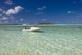 Boat in shallow, tropical water in lagoon.