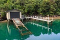 Boat shed, boat ramp and pier, surrounded by forest Royalty Free Stock Photo