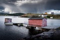 Boat shed overlooking a small bay on the Atlantic Ocean under a stormy sky near Port Rexton Newfoundland Canada Royalty Free Stock Photo