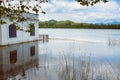 Boat shipping building on the shore of a quiet lake with water reflection mirror effect on a sunny landscape in Banyoles, Cataloni Royalty Free Stock Photo