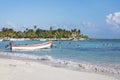 Boat on shore of the Caribbean Sea and people having fun at beach in Tulum, Yucatan Peninsula, Mexico, tropical seascape