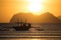 Boat silhouette in the sea on sunset and isles background. Traditional Philippines fishing boat at sunset. Boat in the sea. Royalty Free Stock Photo