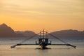 Boat silhouette in the sea on sunset and isles background. Traditional Philippines fishing boat at sunset. Boat in the sea. Royalty Free Stock Photo