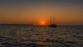 A boat silhouetted against the setting sun in Santorini