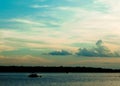 Boat skims across the lake pulling an inner-tube at at the end of the day