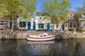 A boat and small brick buildings along a canal