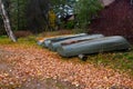 Boat station on the lake in the village. The boats are pulled ashore and turned upside down for winter storage. Many fallen leaves