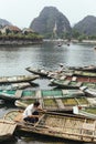 Boat stop on the river with many empty row boats, rowing men and women with mountain in the background in summer. Royalty Free Stock Photo