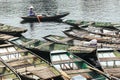 Boat stop on the river with many row boats and rowing woman in summer at Trang An Grottoes in Ninh Binh, Vietnam Royalty Free Stock Photo