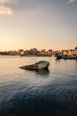 Boat sunk in the port of Taranto Vecchia with the city of Taranto behind it