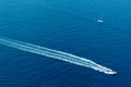 Boat surf foam aerial from prop wash in blue sea