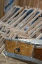 The boat tail of a wooden rowing boat and in the background a series of suspended empty deckchairs lined up in order on the beach Royalty Free Stock Photo