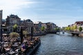 Boat terrace full of people enjoying the sun, food and drinks in the canal of the old town center of Leiden