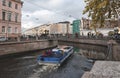 Boat with tourists on the canal in St. Petersburg, Russia, Bank bridge with winged sphinxes in autumn, embankment with old