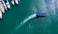 Boat with tourists in the port among the yachts moored to shore, top view from the drone, the trail with the waves behind the boat Royalty Free Stock Photo