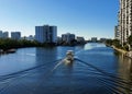 Boat Traveling Waterways in Florida, Against a Blue Sky and Apartment buildings