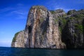 Boat trip along the coast line of tropical island Ko Phi Phi along impressive rock formations under blue sky Royalty Free Stock Photo