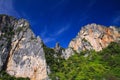 Boat trip along the coast line of tropical island Ko Phi Phi along impressive steep red rock wall rising high into blue sky Royalty Free Stock Photo