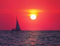 Sea yacht sails against the backdrop of the setting sun