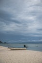 Boat in the tropical sea under gloomy dramatic sky.