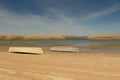 A boat turned upside down. Rowing boats in the reeds. Wooden boat on a grassy lake shore on a summer day. Aral sea Royalty Free Stock Photo