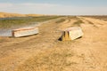 A boat turned upside down. Rowing boats in the reeds. Wooden boat on a grassy lake shore on a summer day. Aral sea, Kazakhstan Royalty Free Stock Photo