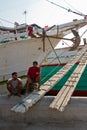 Boat and two workers of the Sunda Kelapa harbour Jakarta, Indone